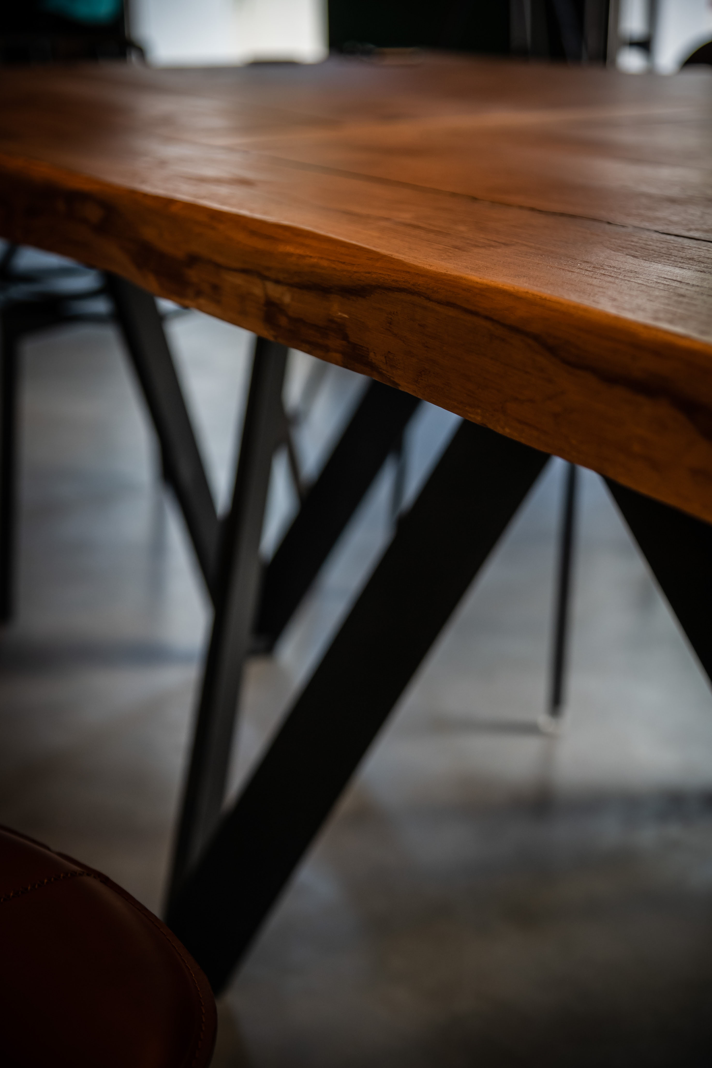 Détail de la table en châtaignier massif et piètement Calligaris